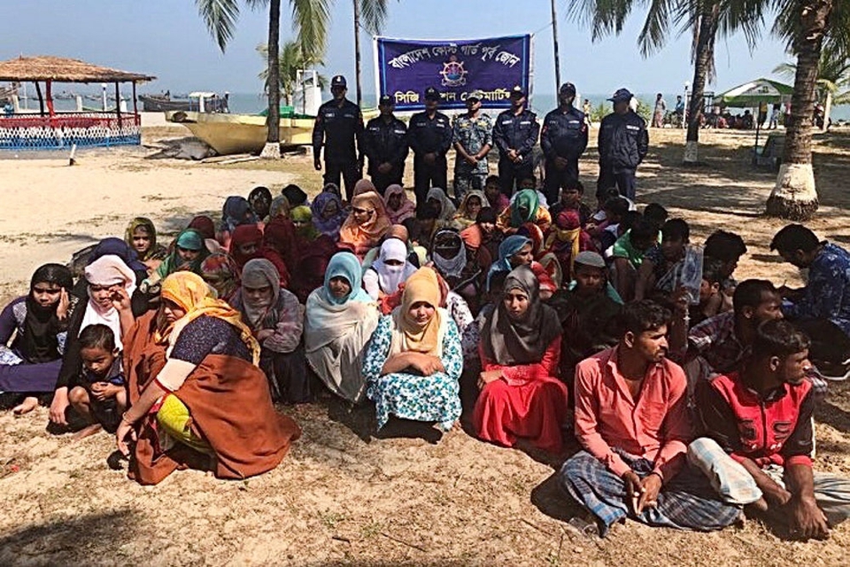 En del af de overlevende fra forlis i Den Bengalske Bugt ses her på en strand i Bangladesh, efter at de var blevet reddet i land af kystvagten.