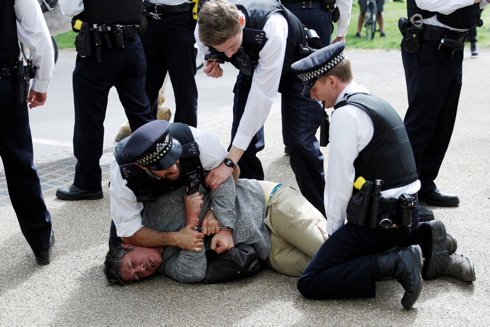 Demonstant overmandet af politi i Hyde Park efter coronakrisens udbrud. Den britiske anklagemyndighed forbereder over 300 straffesager mod personer, som har spyttet eller hostet på politifolk og hospitalsansatte og derefter sagt, at de var syge med Covid-19.