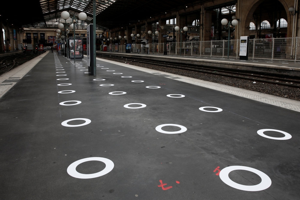 Cirkler er her blevet tegnet på jorden på en togstation i den franske hovedstad, Paris. Det skal få folk til at holde afstand til hinanden.
