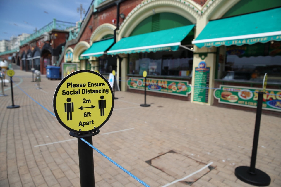 Store dele af Storbritannien er fortsat lukket ned, og overalt er der påmindelser om at holde afstand til hinanden - som her ved en strandpromenade i badebyen Brighton i det sydlige England.