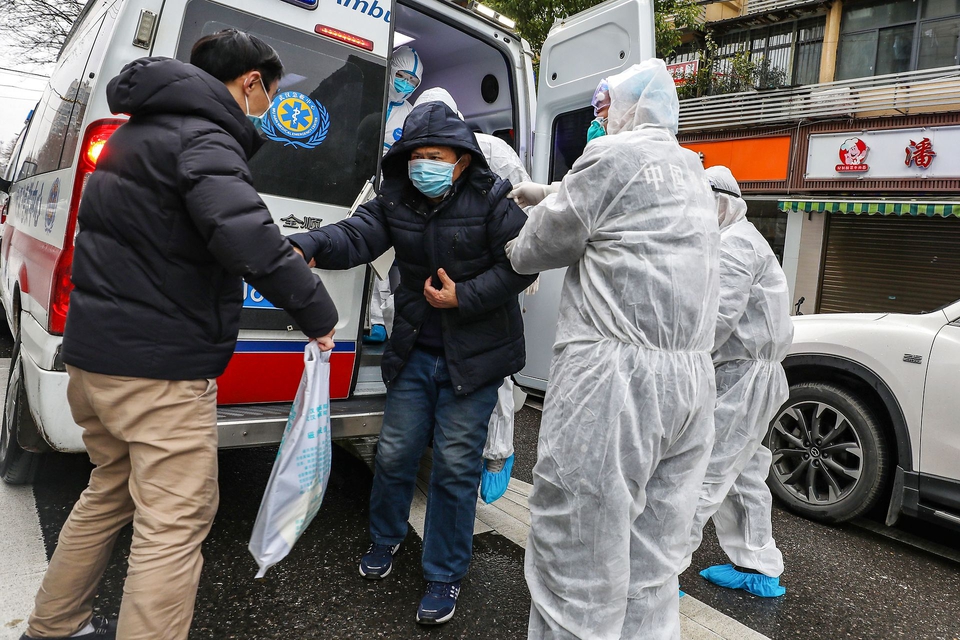 En patient bliver hjulpet ud af en ambulance af lægefolk med beskyttelsesmasker og dragter, der skal hindre smittte af den dødelige virus. Wuhan i Kinas Hubei-provins er epicenteret for coronovirusset. (Foto: AFP/Ritzau Scanpix)