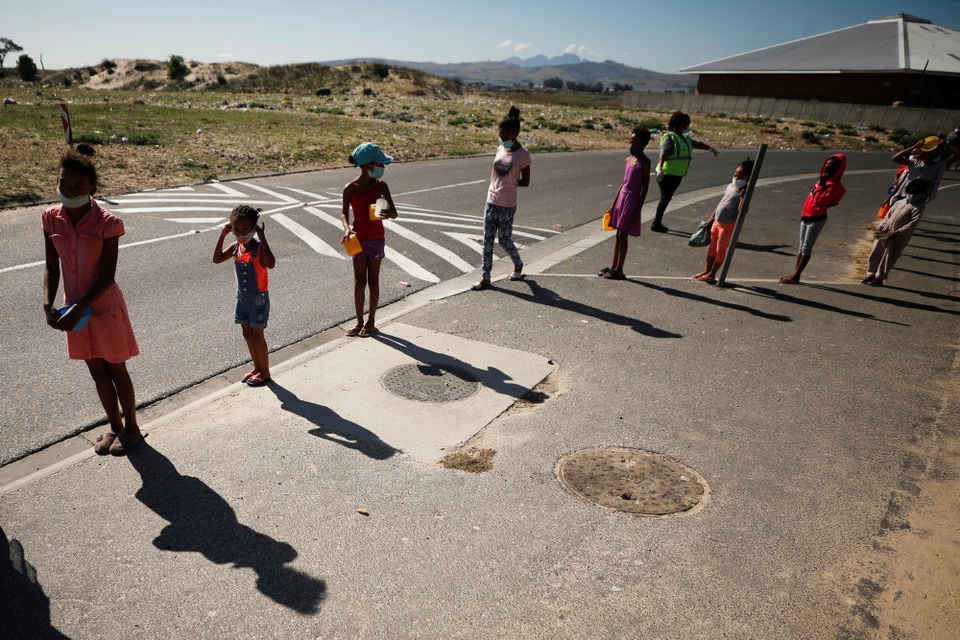 Nedlukning af skoler og påbud om at undgå fysisk kontakt udløser angstfølelser hos mange børn. Det fremgår af en ny rapport fra Red Barnet. Arkivfoto er fra Sydafrika, hvor børn står i kø til et måltid mad.