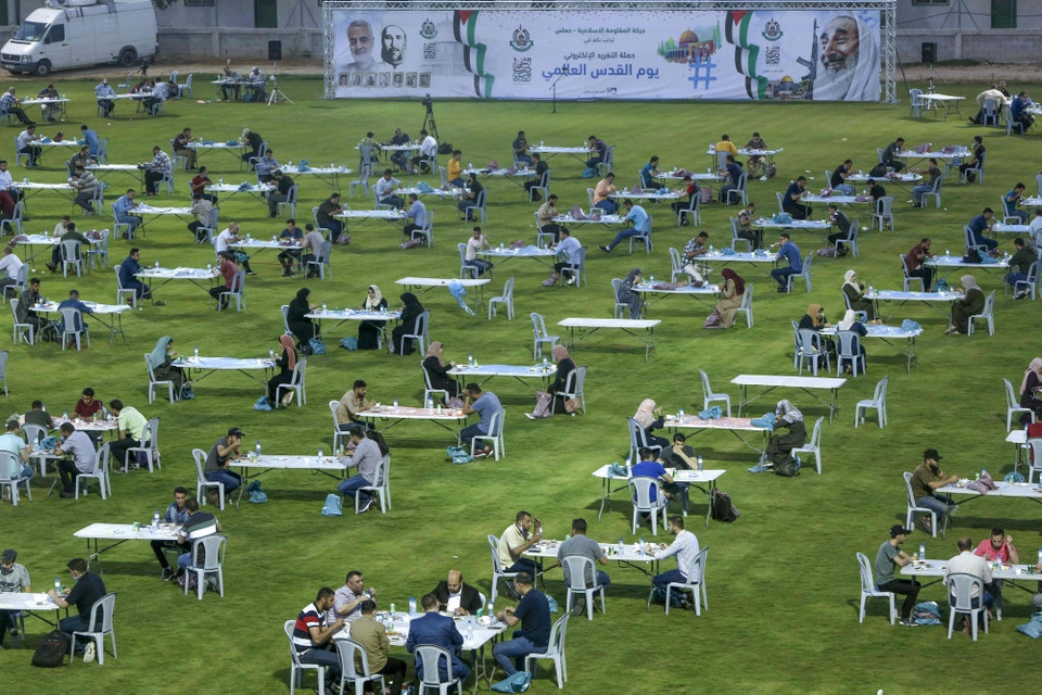 Med behørig afstand mellem sig indtog palæstinensere i Gaza fredag aften iftar-måltidet, der afslutter den daglige faste under ramadanen. Hamas-bevægelsen, der kontrollerer Gaza, havde opstillet hundredvis af borde på et fodboldstadion i Gaza City.
