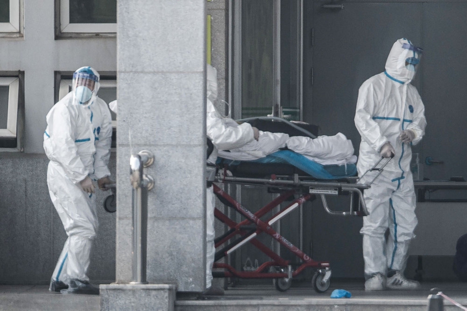 Sundhedsmedarbejdere kører en båre med en patient ind på et hospital i millionbyen Wuhan i den centrale provins Hubei lørdag. Forskere har advaret om, at omfanget af det ukendte, sars-lignende virus kan være større end hidtil antaget.